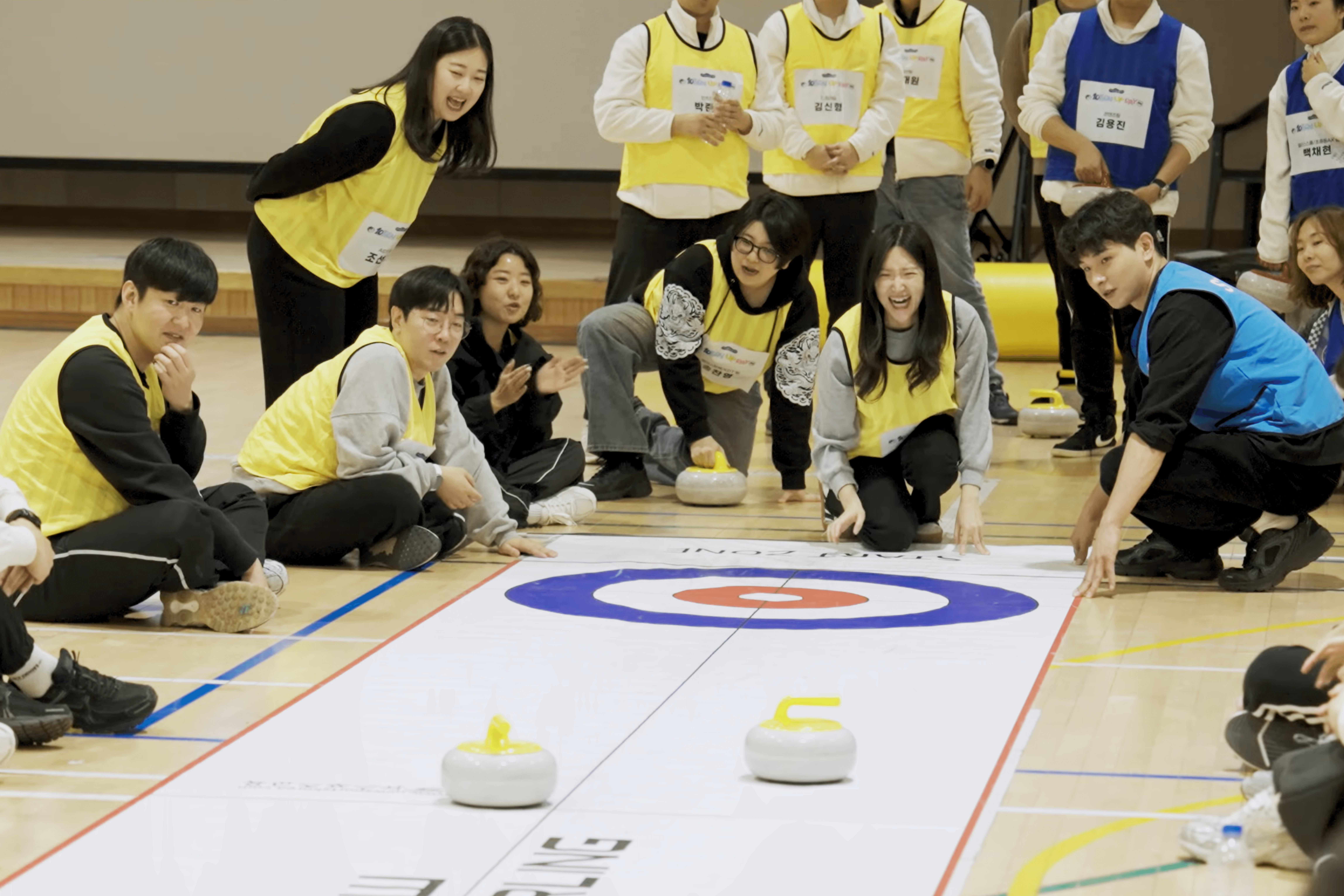 엘리스 10주년 명랑 운동회에서 팀원들이 함께 전략을 논의하며 실내 컬링 경기에 참여하는 모습