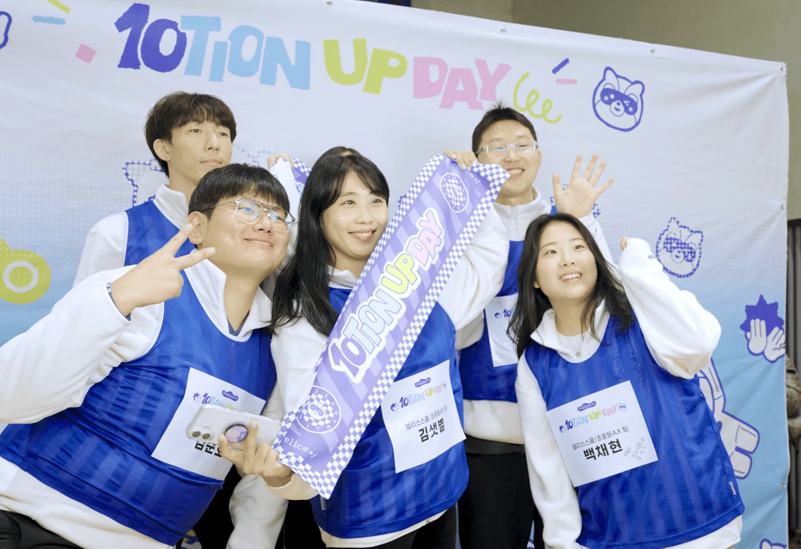 엘리스 10주년 명랑 운동회 포토 부스에서 소품을 착용한 엘리서들이 팀별 기념 사진을 촬영하는 장면